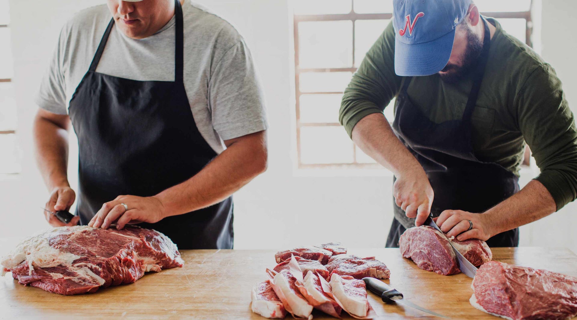 Porter Road founders Chris Carter and James Peisker cutting steaks at the butcher block